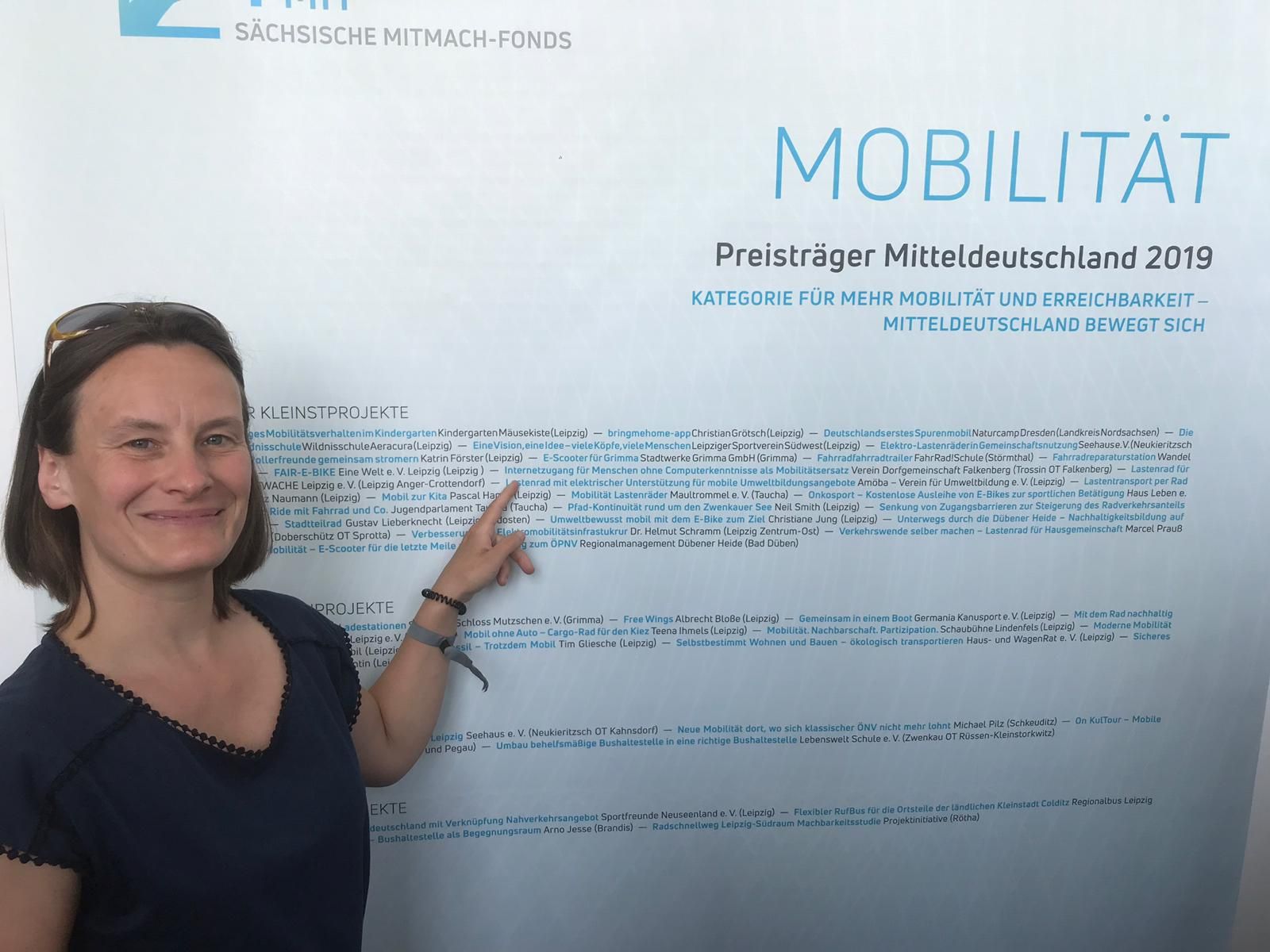 Amöba Mitglied vor der Preisträgerwand